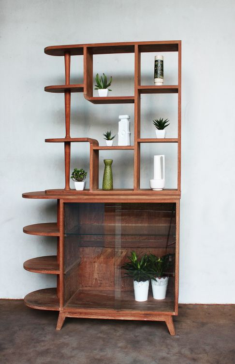 a shelf that has some plants on top of it and two potted plants in the bottom