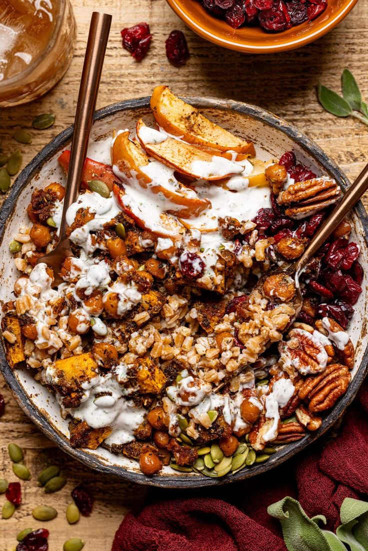 a bowl filled with granola, nuts and cranberries on top of a wooden table