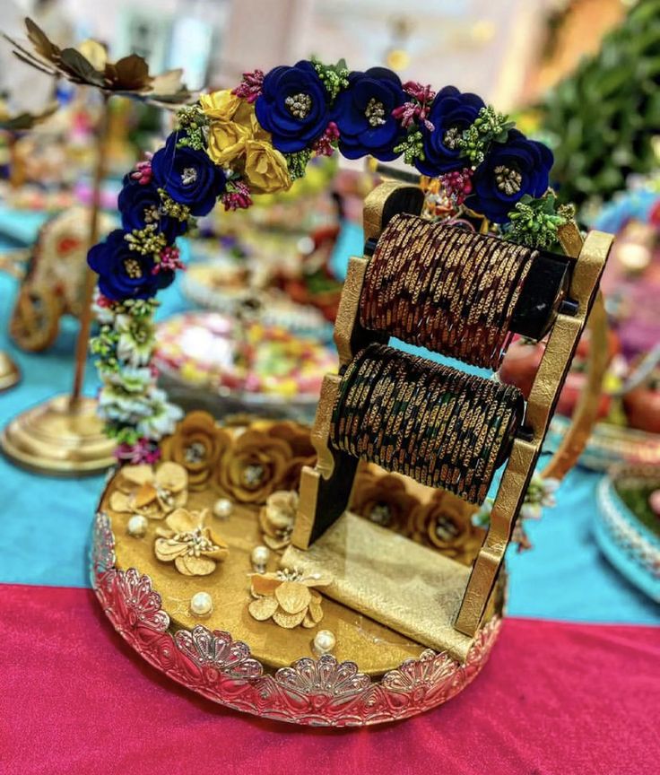 an elaborately decorated chair sits on top of a table covered in blue and gold flowers