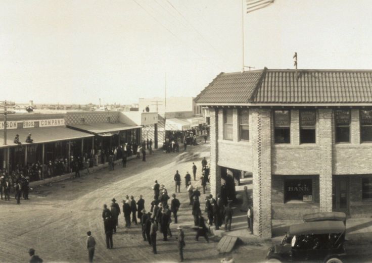 an old black and white photo of people standing in front of a building