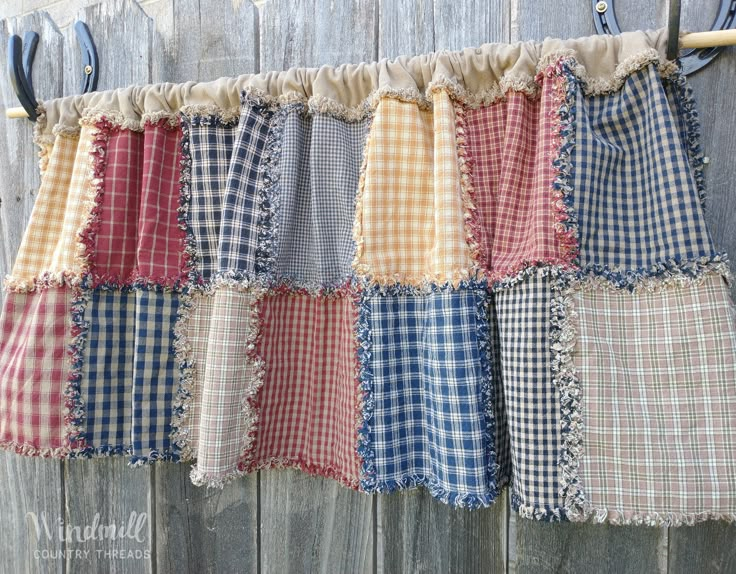 an old curtain is hanging on the side of a wooden fence