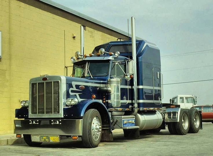 a blue semi truck parked in front of a building