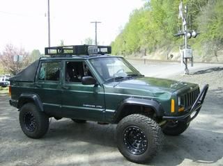 a green jeep parked on the side of a road