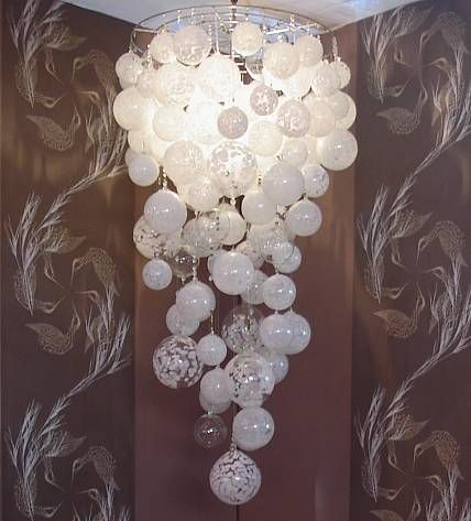 a chandelier hanging from the ceiling in front of a wallpapered background