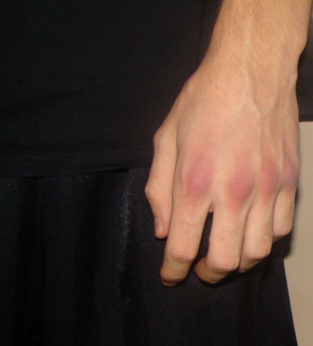 a close up of a person's hand holding something in their left hand and wearing a black dress