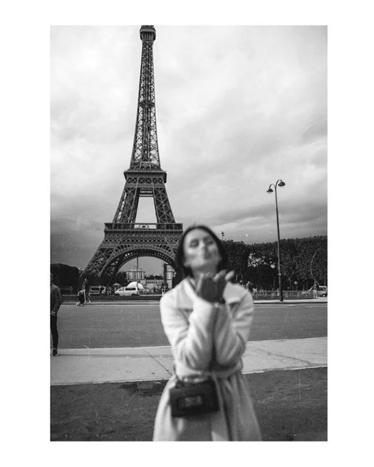 a woman standing in front of the eiffel tower with her hands on her face