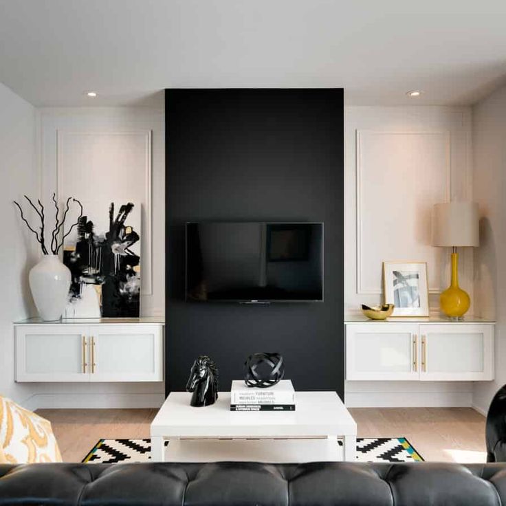 a black and white living room with modern decor on the wall, leather couches and coffee table