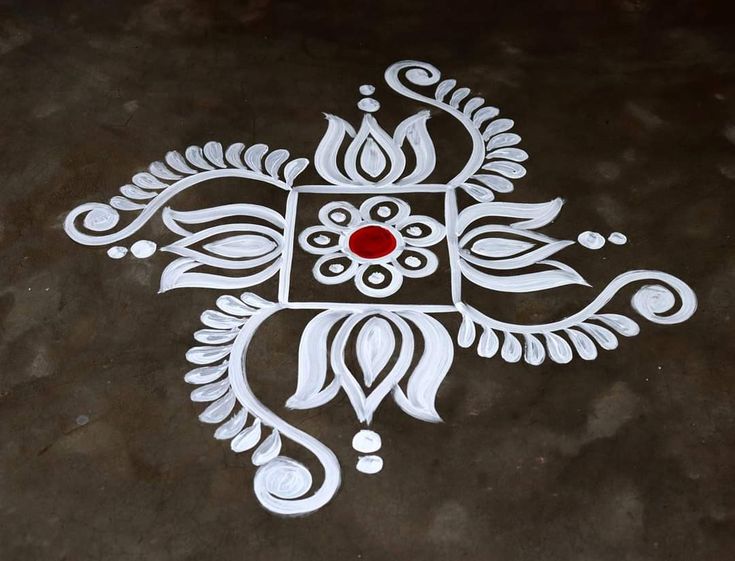 an intricately designed design on the ground with red stone in center and white paint