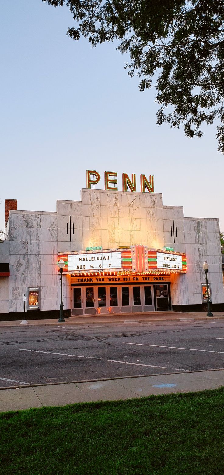 an old theater with the word penn on it's marquee at dusk