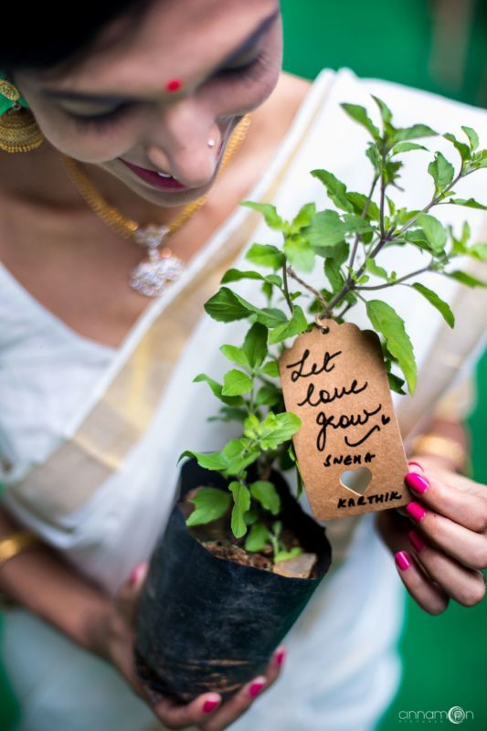 a woman holding a potted plant with writing on it