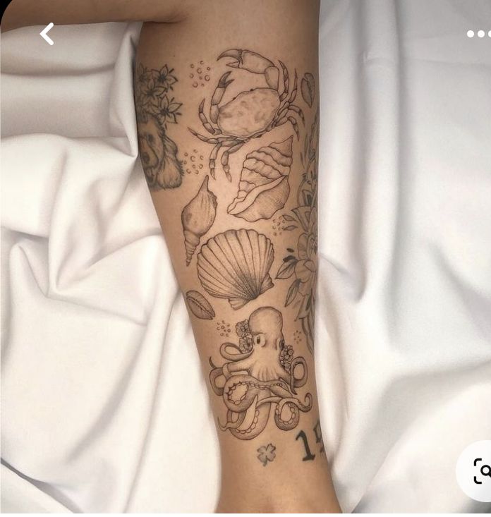 a woman's leg with tattoos on it and an octopus, crab, shellfish