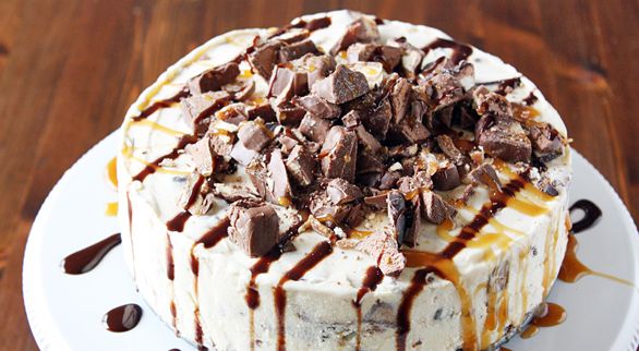 a cake covered in chocolate chips and drizzled with caramel on top