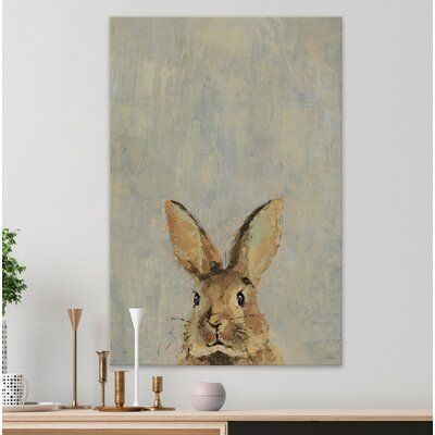 a painting of a brown rabbit on a wall above a wooden table with vases