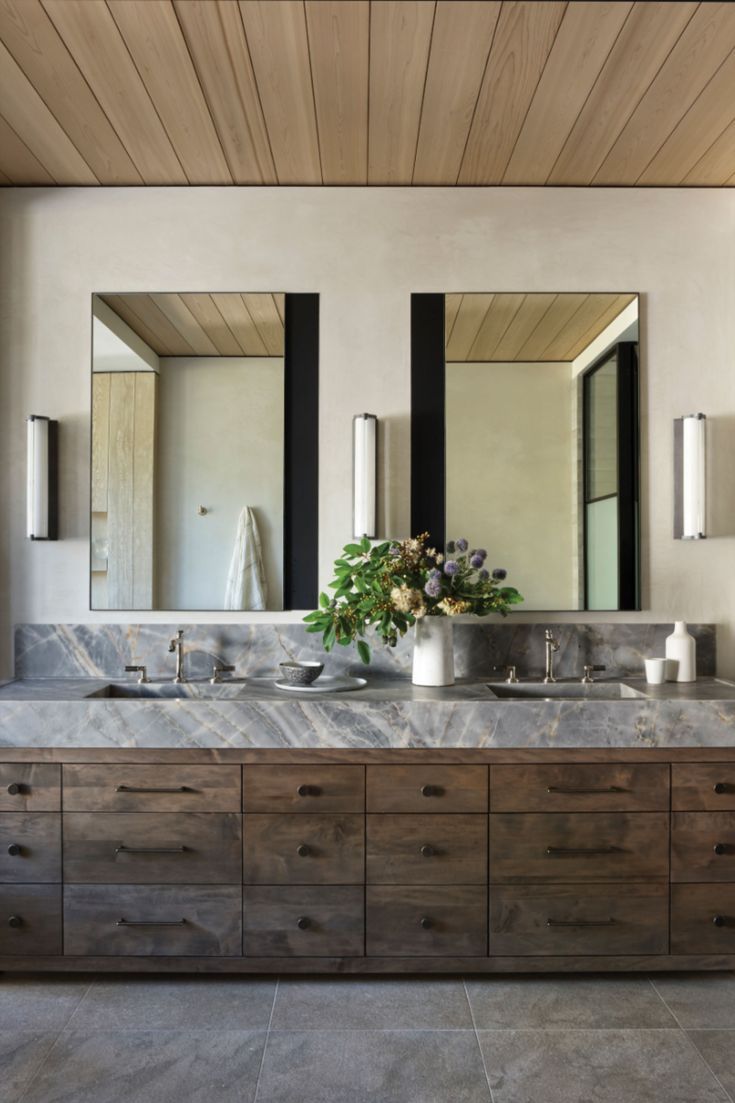 a bathroom vanity with two sinks and mirrors