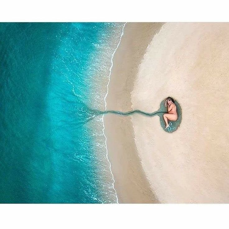 an aerial view of a woman laying on the beach