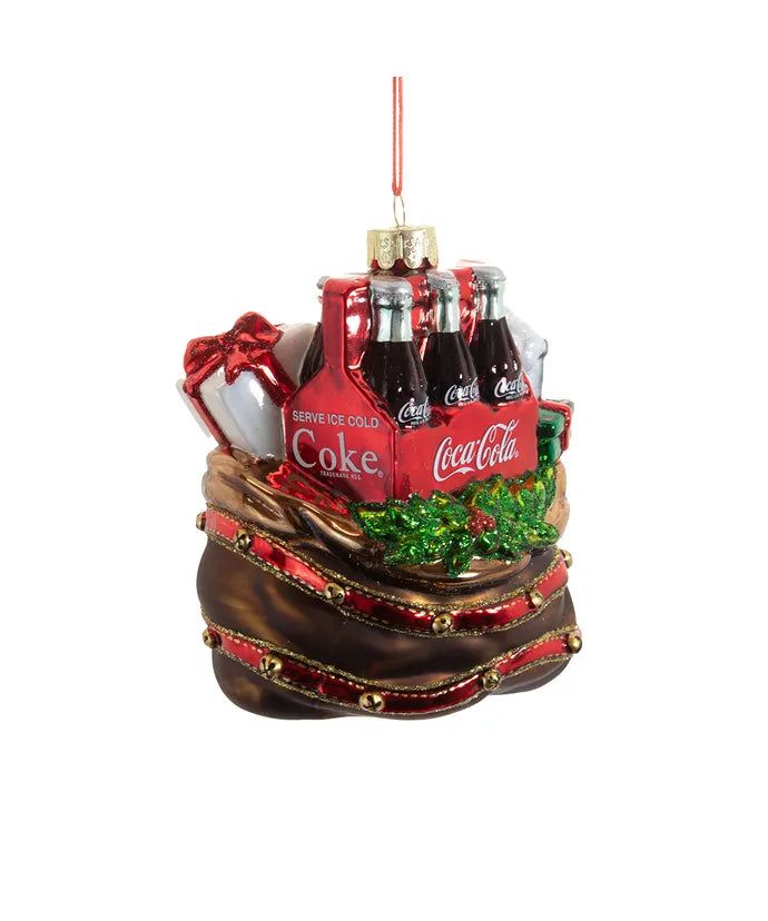 a christmas ornament with coca - colas and other holiday items in it