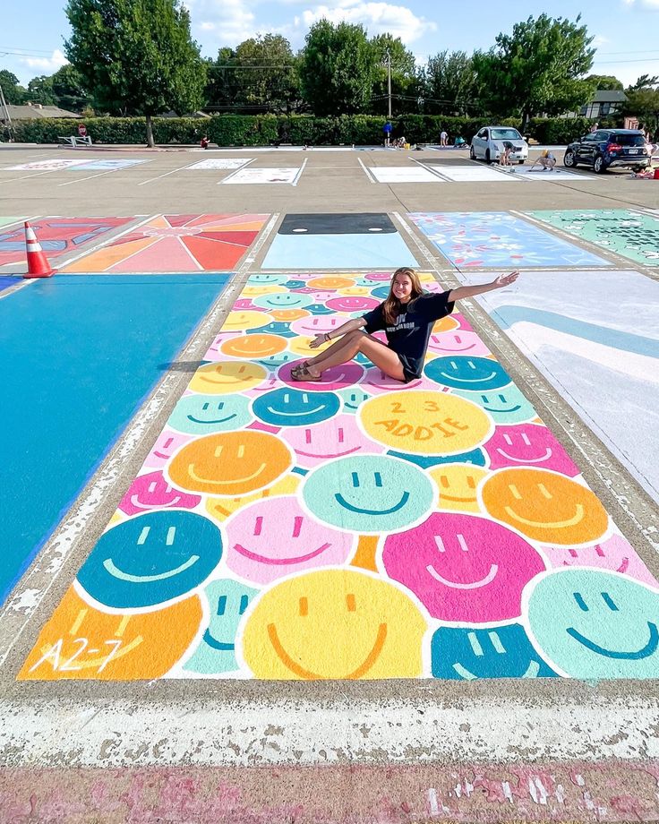 a woman laying on top of a colorfully painted parking lot