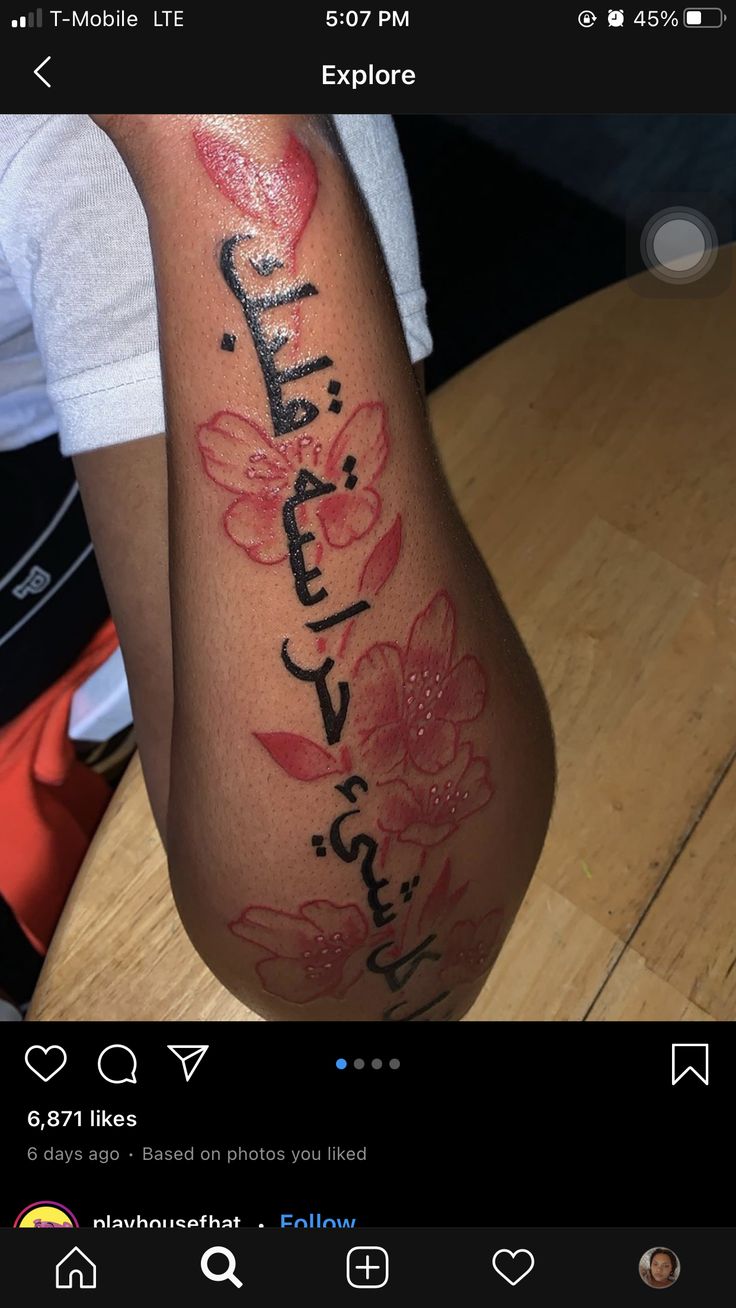 a woman's arm with the word love written on it and flowers painted on it