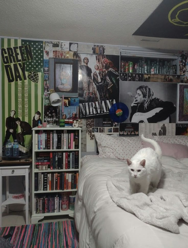 a white cat sitting on top of a bed in a bedroom