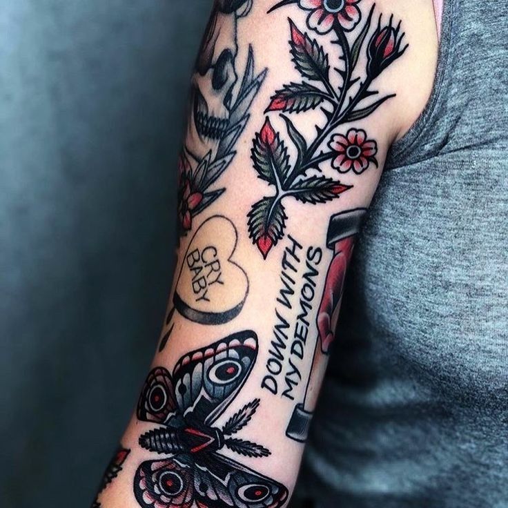 a woman's arm with tattoos on it, including flowers and butterflies in the background