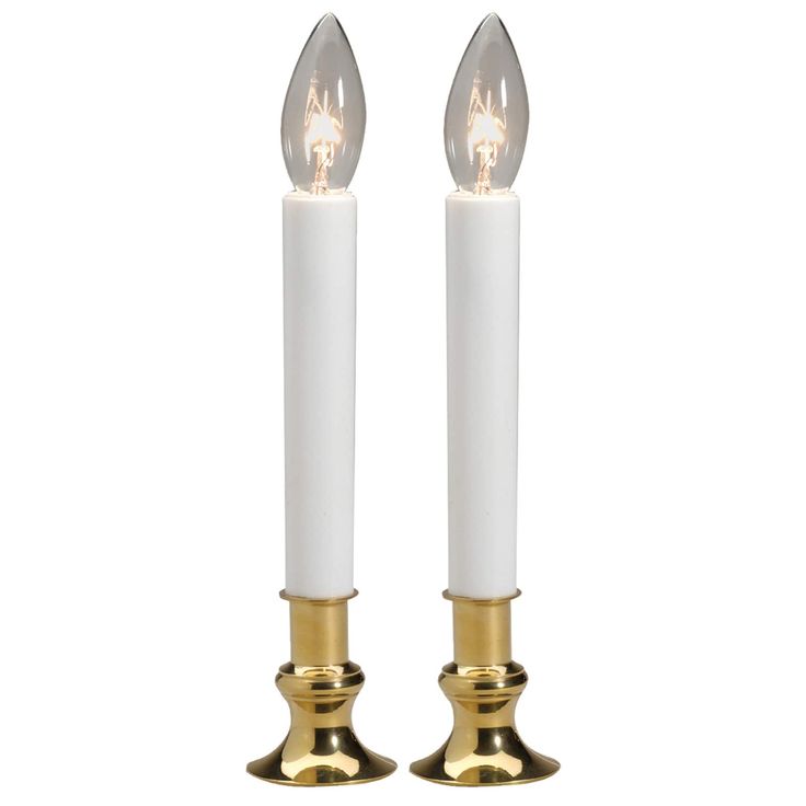 two white candles with gold accents on each candle holder, one is lit and the other is turned off