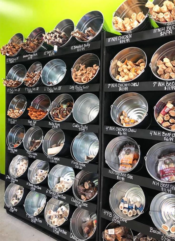 a display case filled with lots of different types of food in plastic containers on top of metal pans