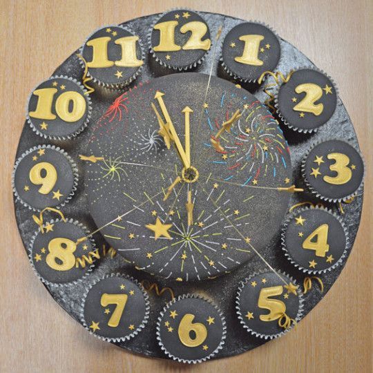 a clock made out of cupcakes with numbers and fireworks on the front side