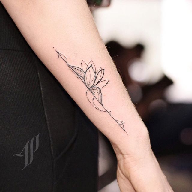 a woman's arm with a tattoo on it that has a flower and arrow