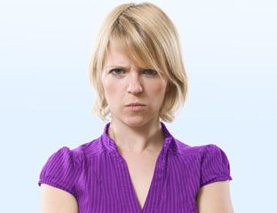 a woman in a purple shirt is looking at the camera with her arms folded out