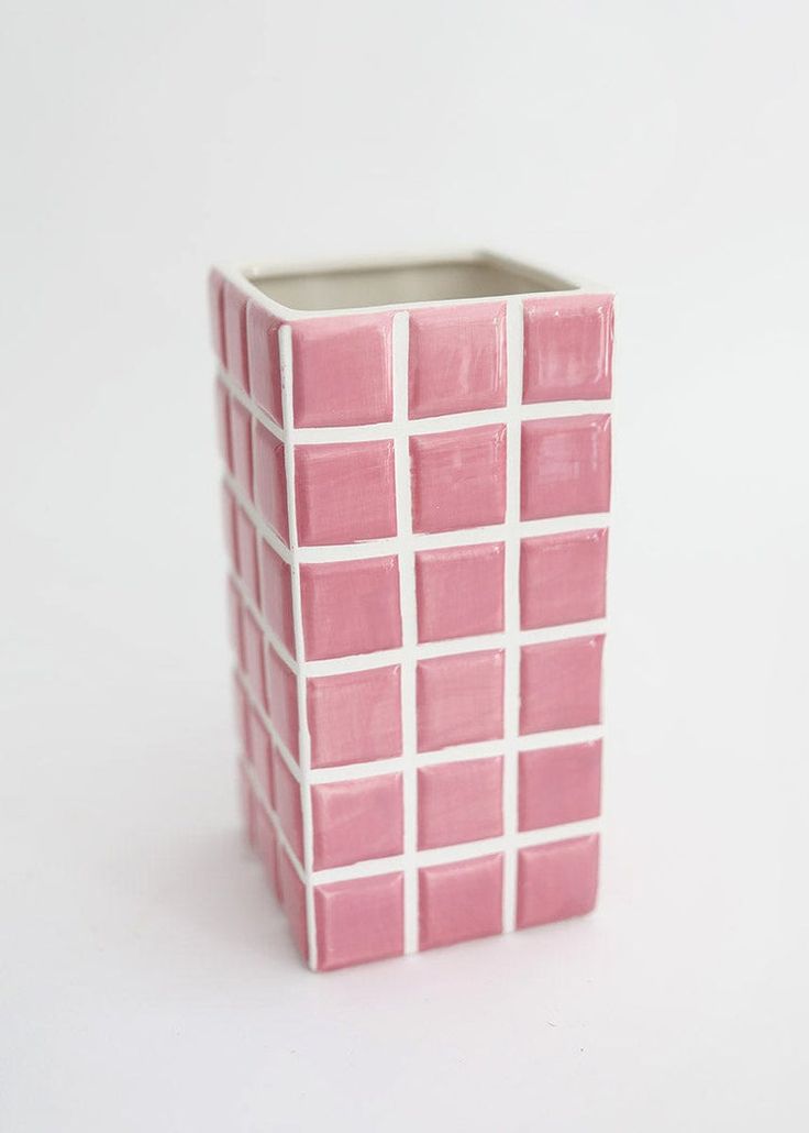 a pink and white vase sitting on top of a table