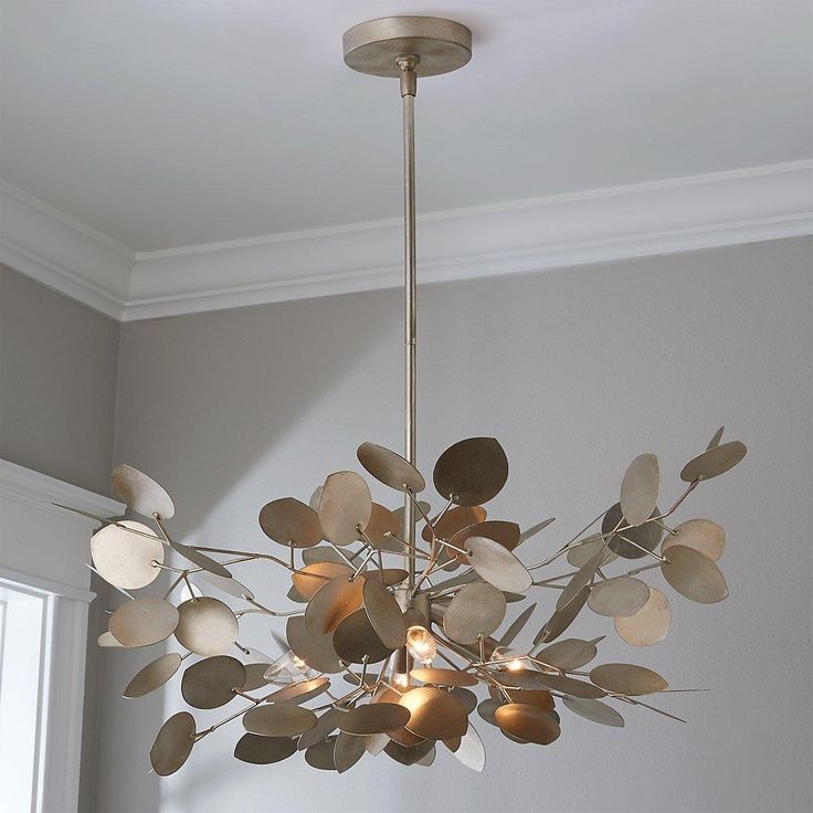 a chandelier hanging from the ceiling in a room with gray walls and white trim