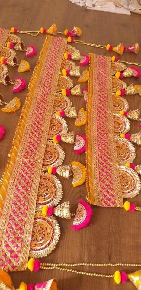 an elaborately decorated table cloth with tassels and pom poms on it