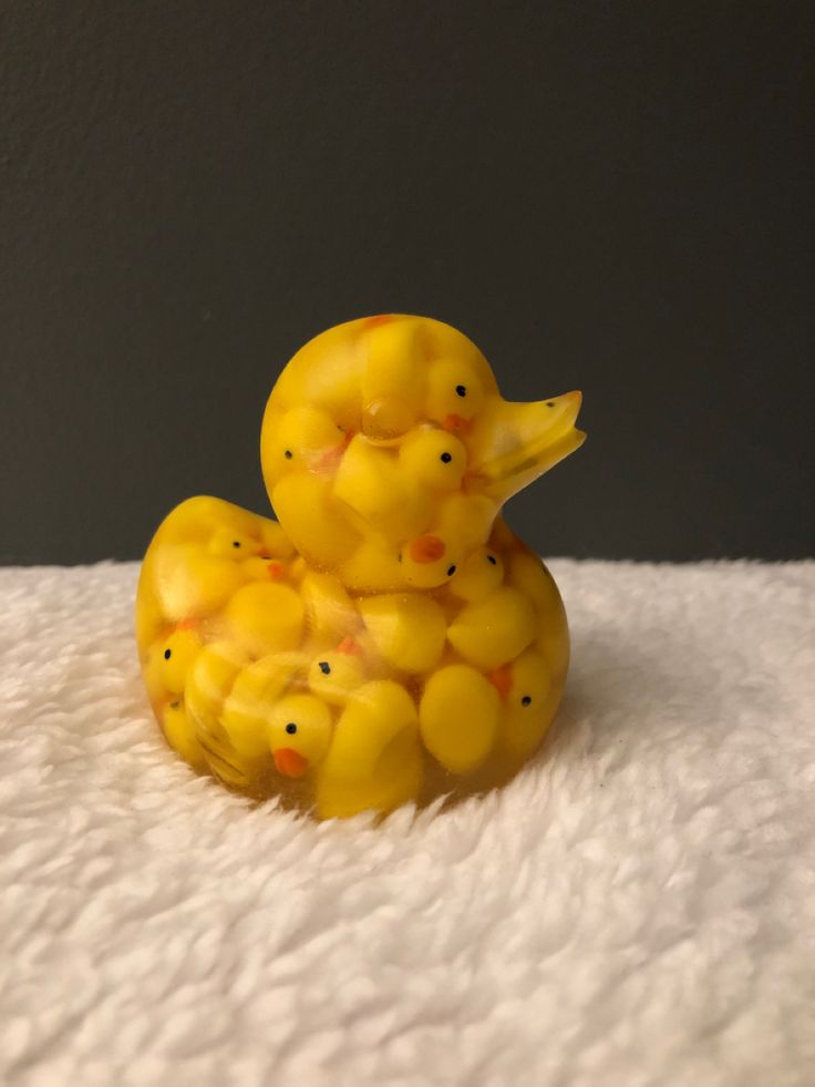 a yellow rubber ducky sitting on top of a white blanket