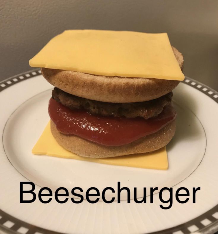 a cheeseburger with ketchup and mustard on a plate that says, cheeseburger