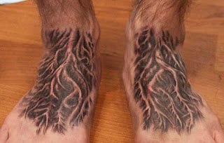 a man's foot with a tree tattoo on it