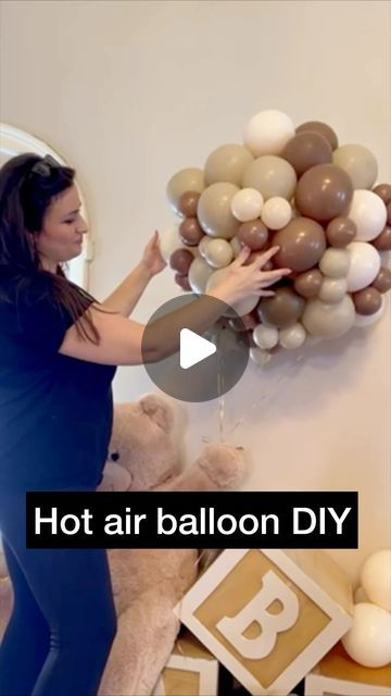 a woman is holding balloons in front of a wall with the words hot air balloon diy on it