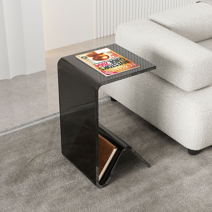 a table with a magazine on it in the middle of a living room next to a couch