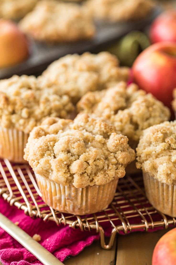 muffins on a cooling rack with apples in the background