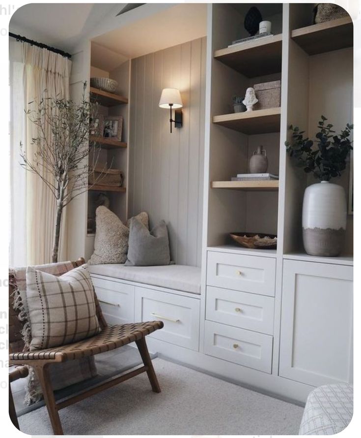 a living room with white furniture and shelves filled with vases, plants and other items