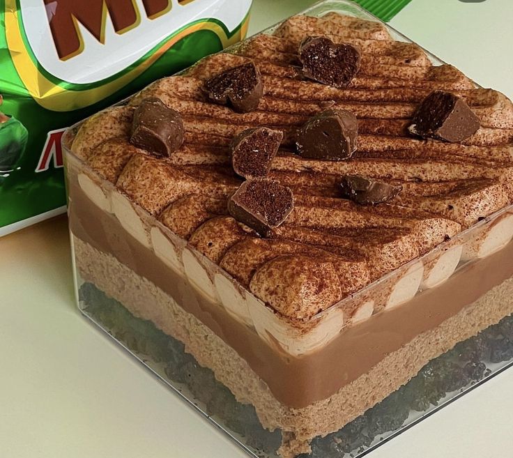 a chocolate cake sitting on top of a table next to a box of m & m