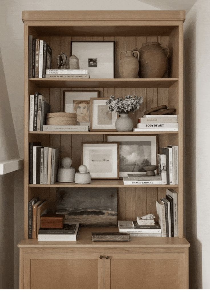 a book shelf with books and pictures on it