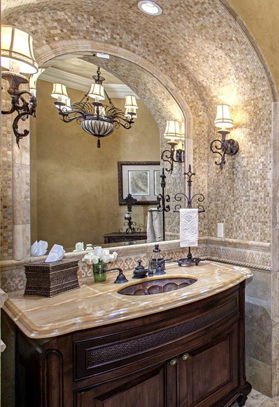 a bathroom with a sink, mirror and chandelier in it's center