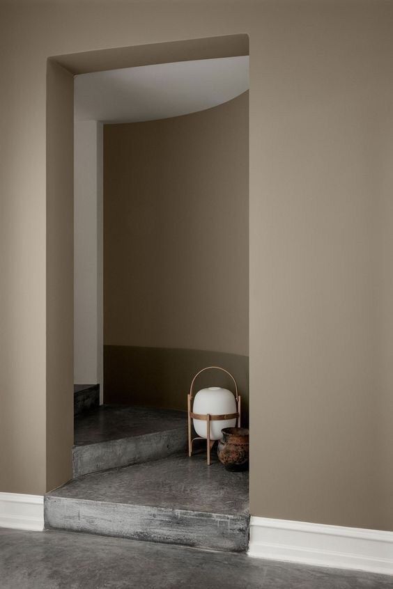 a chair sitting on top of a cement floor next to a wall with an open doorway