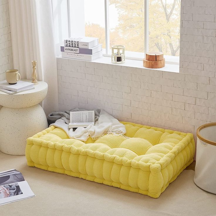 there is a yellow bed in the middle of this room with white bricks on the wall