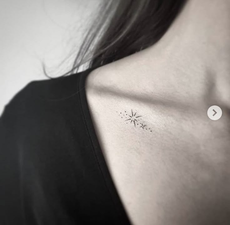 a woman's chest with a small tattoo on the left side of her neck