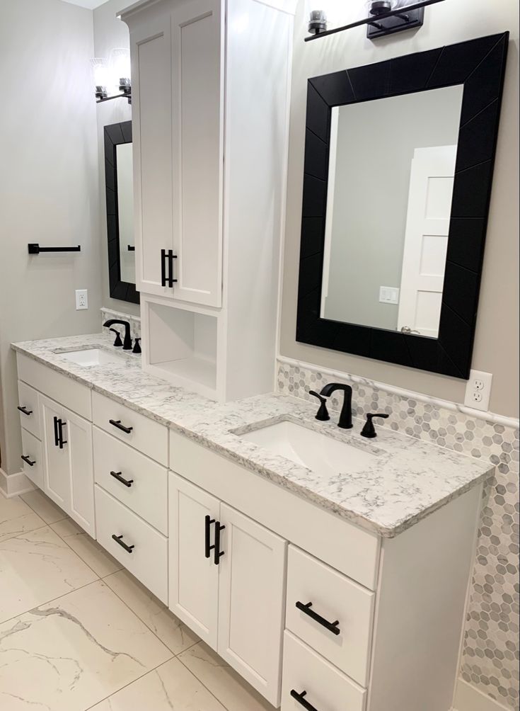 a bathroom with two sinks, mirrors and cabinets in the middle of the flooring