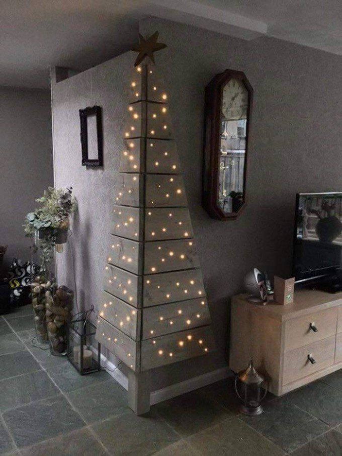 a living room with a christmas tree on the wall and a mirror in the corner