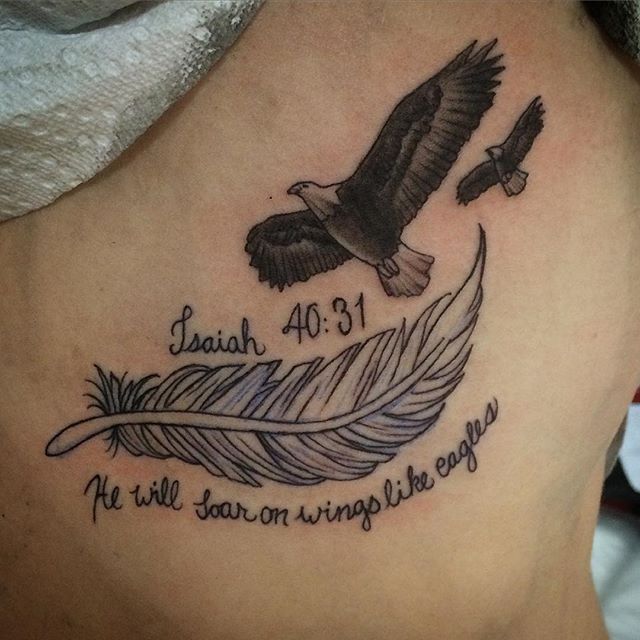 a tattoo on the back of a woman's stomach with an eagle and feather