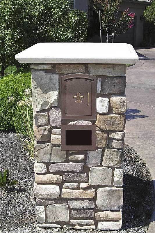 a stone mailbox with a white roof