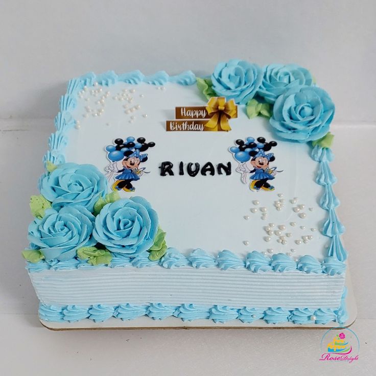 a birthday cake decorated with blue roses and mickey mouse